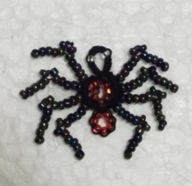 black spider with beaded legs and red bead interior tatted by Marie McCurry